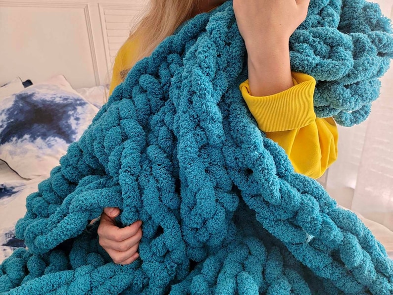 Pu&ograve; includere: Una coperta in maglia grossa color turchese con una texture morbida e soffice. La coperta &egrave; realizzata con filato spesso e ha una trama larga e aperta.