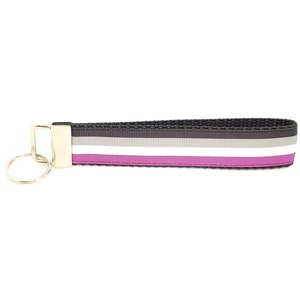 May include: A black, gray, white, and purple striped key chain with a gold metal ring.