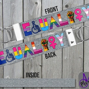 May include: A gray lanyard with the word "EQUALITY" in rainbow colors and symbols for disability, LGBTQ+ pride, and the raised fist. The front and back of the lanyard are visible, along with the inside and a metal clasp.