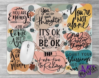 May include: A colorful mouse pad with inspirational quotes and abstract shapes. The quotes include "You are enough", "You're not alone", "It's OK to not be OK", "Grow positive thoughts", "Take time to recharge", and "Count your blessings, not your worries".