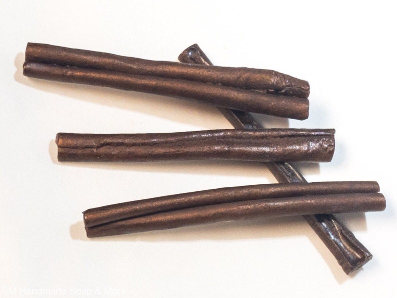 May include: Four brown leather cords, each about 10 inches long, are arranged in a random pattern on a white surface.