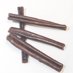 May include: Three brown chew sticks for dogs. The sticks are made of a durable material and are designed to help clean teeth and freshen breath.