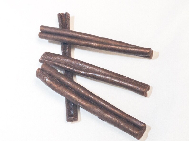 May include: Three brown chew sticks for dogs. The sticks are made of a durable material and are designed to help clean teeth and freshen breath.
