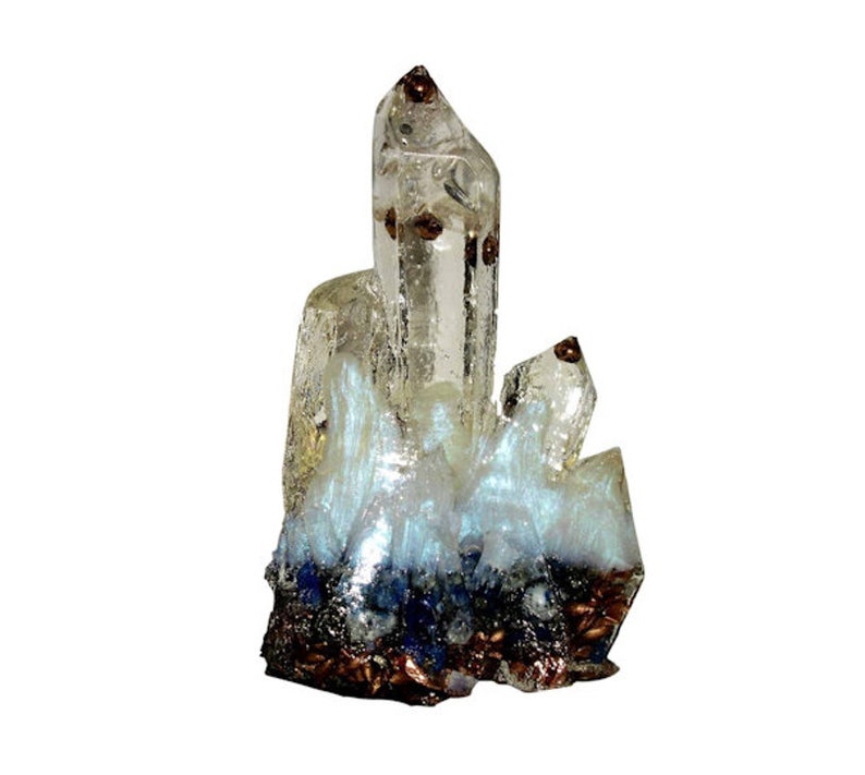 May include: A clear quartz crystal cluster with brown inclusions and a blue and white iridescent base. The crystal has a pointed, elongated shape with multiple facets. The base is a mix of dark blue and brown.