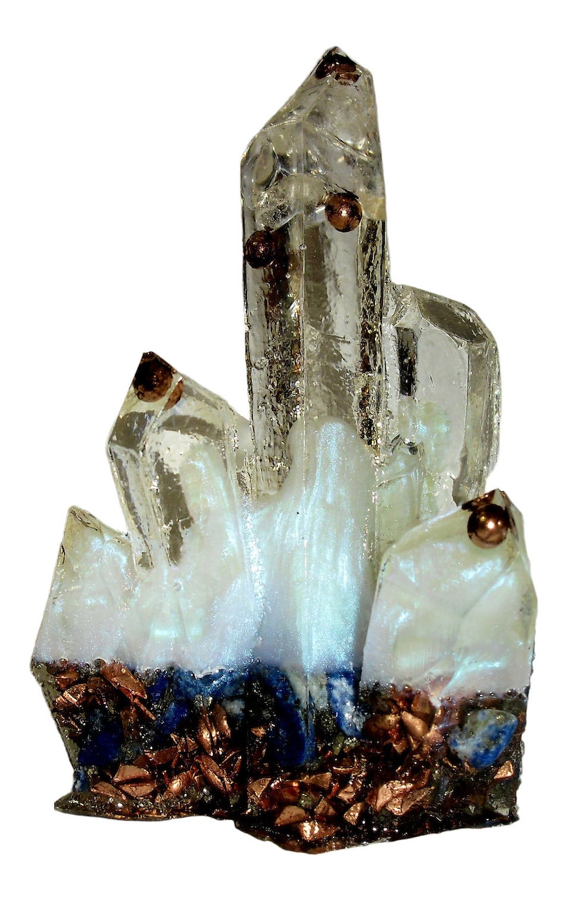 May include: A clear quartz crystal cluster with copper accents and a white base. The crystal has multiple points and is partially coated in a white, iridescent material. The base features copper and blue mineral fragments.
