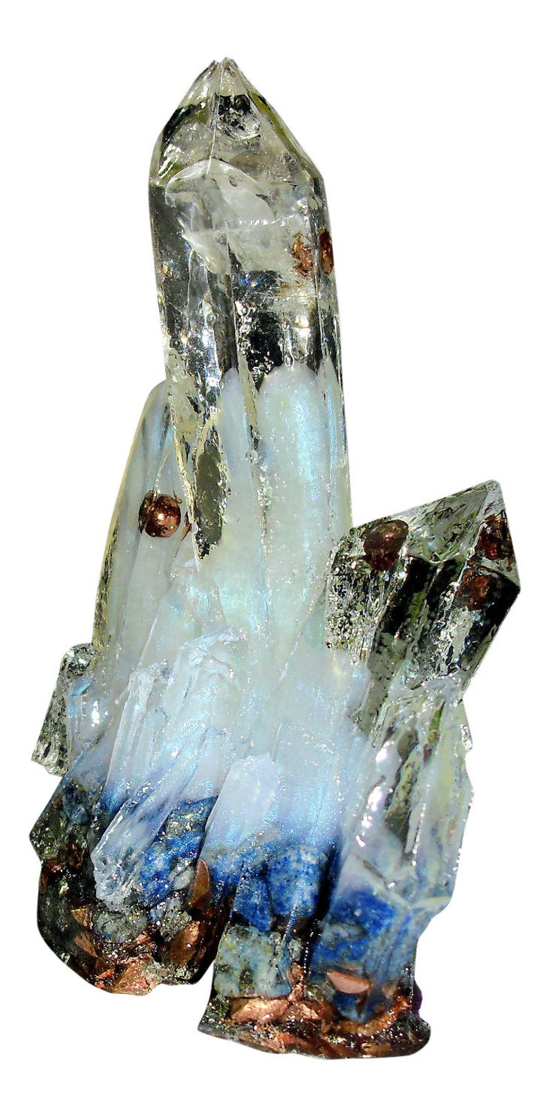 May include: A cluster of clear quartz crystals with iridescent blue and white hues. The crystals have sharp points and are accented with small, copper-colored inclusions. The base of the cluster features dark blue and gray mineral deposits.