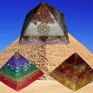 May include: Three pyramid-shaped objects with layered textures. The top pyramid features a gold-coloured geometric flower design. The bottom left pyramid has purple, blue, and green layers. The bottom right pyramid displays red and yellow tones.