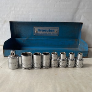 May include: A set of eight silver socket wrenches in a blue metal case. The wrenches are labeled with sizes in fractions of an inch and the words "U.S.A.". The case has the word "Kraeuten" printed on it.