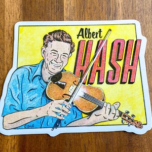 May include: A sticker featuring a cartoon illustration of a man playing a violin. The man is wearing a blue shirt and has a light brown beard. The text "Albert Hash" is written in red and white letters on a yellow background.
