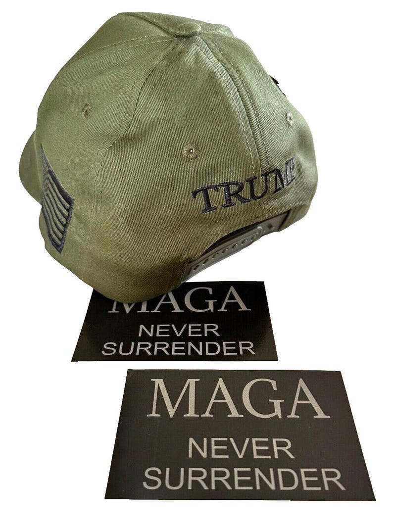 May include: A green baseball cap with a black embroidered American flag on the side and the word "TRUMP" embroidered on the back. Two black stickers with white text that reads "MAGA NEVER SURRENDER" are included.