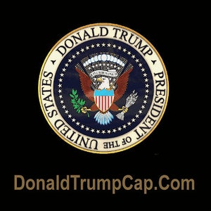 May include: A blue and gold presidential seal with the words "Donald Trump President of the United States" around the edge. The seal features a bald eagle with a shield on its chest and a banner that reads "E Pluribus Unum". The text "DonaldTrumpCap.com" is displayed below the seal.