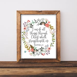 Puede incluir: Un diseño de arte de pared imprimible con una corona de flores sobre un fondo blanco. El texto dentro de la corona dice "Puedo hacer todas las cosas por medio de Cristo que me fortalece Filipenses 4:13".