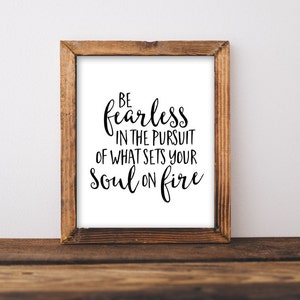 May include: A framed print with a white background and black text that reads "Be fearless in the pursuit of what sets your soul on fire."