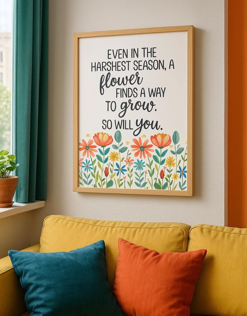May include: A framed print with the text "EVEN IN THE HARSHEST SEASON, A flower FINDS A WAY TO grow. SO WILL you." The print features a floral border with orange, red, blue, and yellow flowers. The frame is light brown.