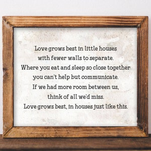 May include: A framed print with a white background and black text that reads: "Love grows best in little houses with fewer walls to separate. Where you eat and sleep so close together you can't help but communicate. If we had more room between us, think of all we'd miss. Love grows best, in houses just like this."