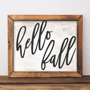 May include: A wooden framed sign with a white background and black calligraphy that reads "hello fall".