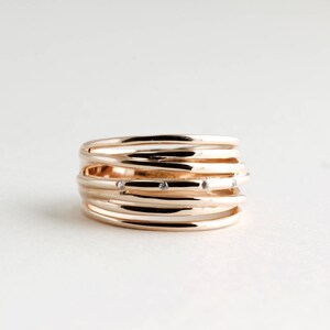 May include: A gold ring with multiple bands and small diamonds set into the metal.