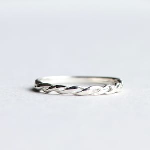 May include: A silver braided ring with a simple design.
