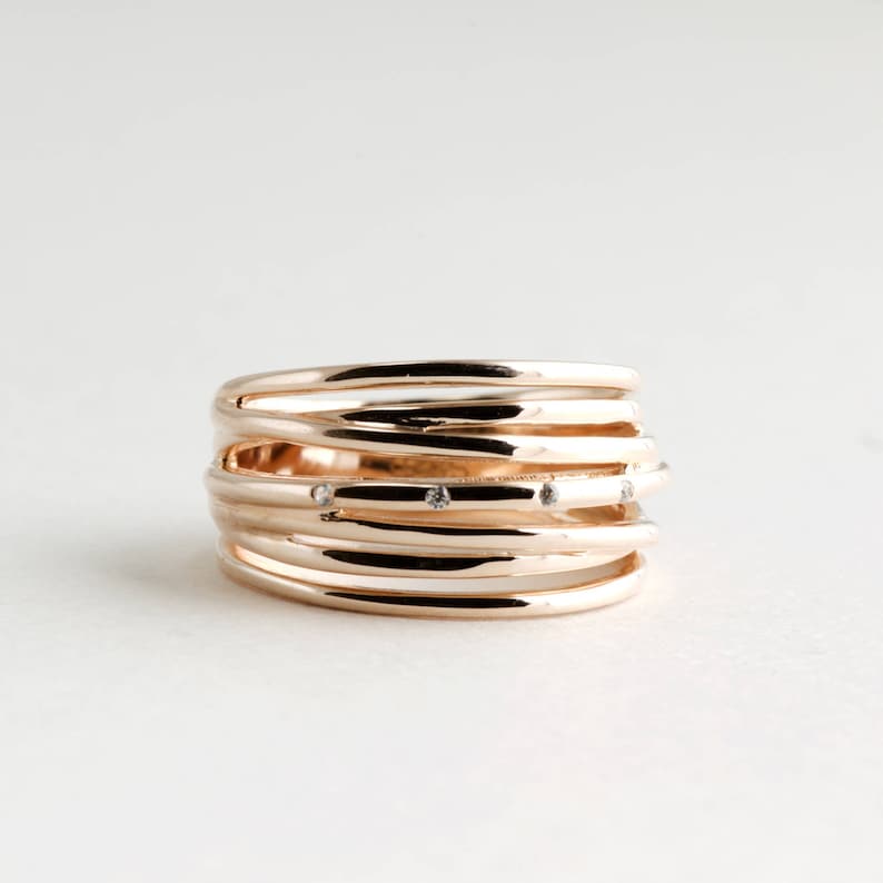 May include: A gold ring with multiple bands and small diamonds set into the metal.