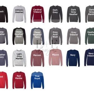May include: A collection of crewneck sweatshirts in various colors, including black, grey, red, and navy. Each sweatshirt has a solid color with the name of the color printed in white text above it. The sweatshirts are displayed on a white background.