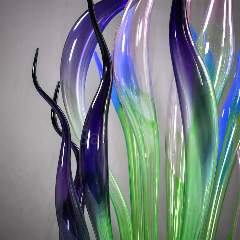 Macro shot of rich purple and iridescent lavender glass accents, highlighting the color gradients and delicate organic shapes of the blown glass sculpture
