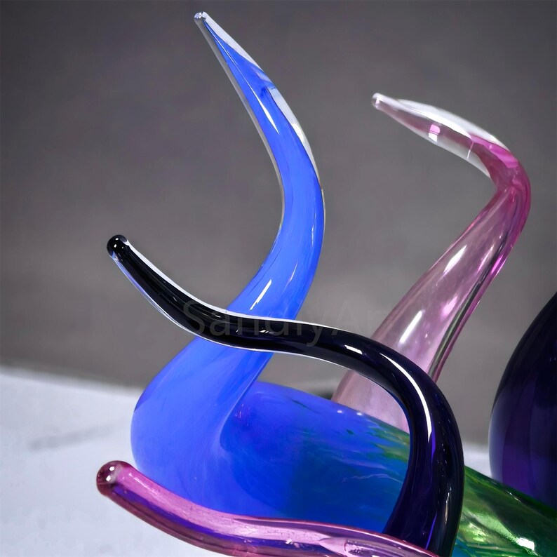 Close-up of vibrant sky-blue hand-blown glass reeds, showcasing the smooth, glossy texture and flowing flame-like curves of this Chihuly-style sculpture