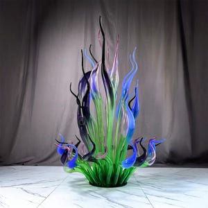 Colorful abstract glass art sculpture with gradient green-to-blue/purple/black organic shapes, designed as a statement centerpiece for luxury home interiors
