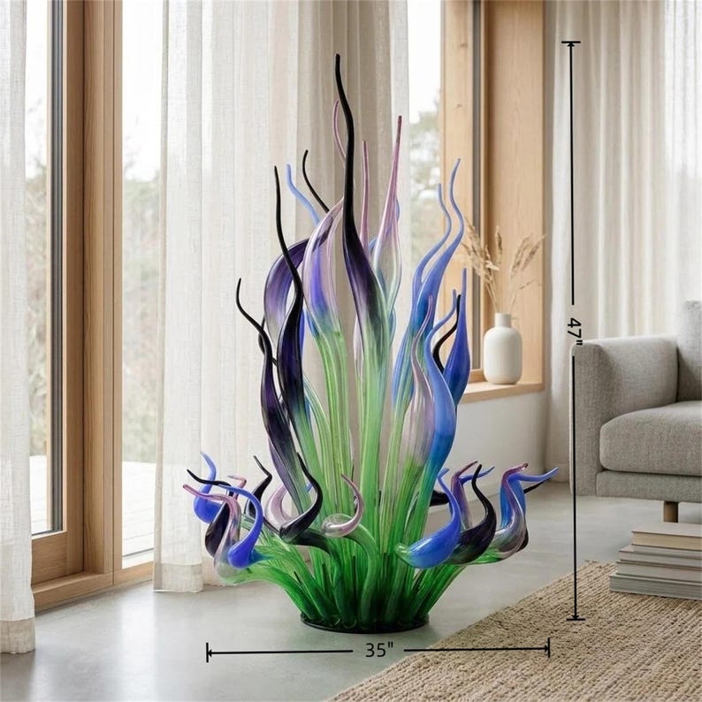 Chihuly-style hand-blown glass sculpture with dimensions 47" tall and 35" wide, featuring green, blue, purple, and black organic forms in a modern living room