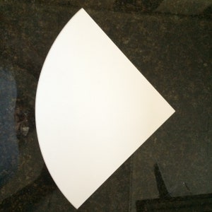 May include: A white, quarter-circle shaped piece of paper or cardboard.