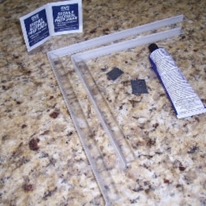 Puede incluir: Un juego de dos soportes de estantería de metal blanco, un tubo de adhesivo y dos pequeños cuadrados de respaldo adhesivo. El embalaje del adhesivo incluye el texto "CVS STAINLESS STEEL PREP & SEAL".