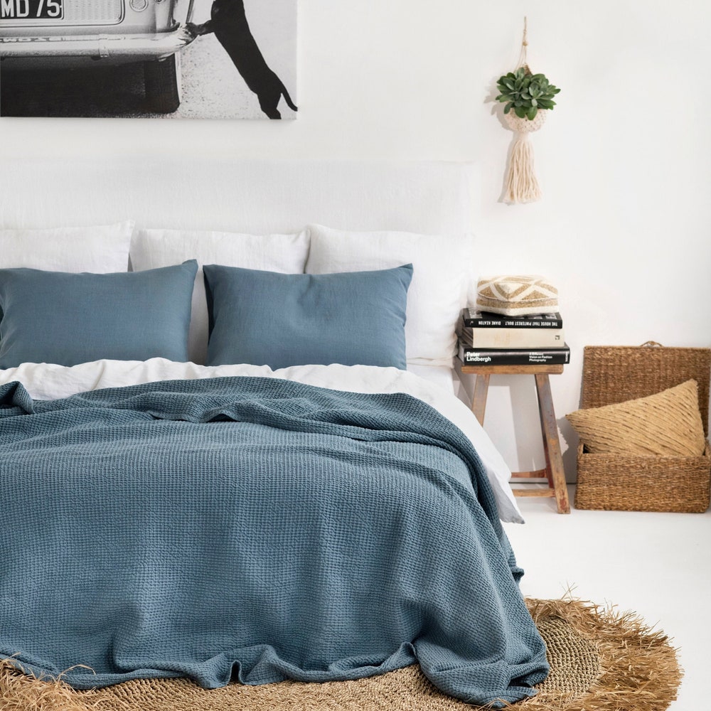 A gray blue linen waffle bedspread on a bed.