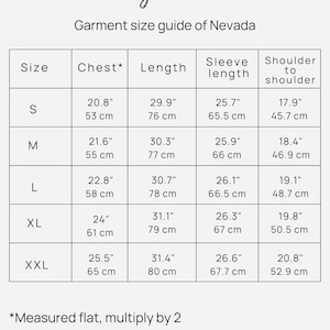 Pu&ograve; includere: Tabella delle taglie per l'abbigliamento Nevada, che mostra le misure di petto, lunghezza, manica e spalla a spalla in pollici e centimetri per le taglie S, M, L, XL e XXL.