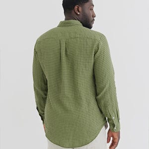 K&ouml;nnte beinhalten: Gr&uuml;nes Gingham-Hemd mit Kn&ouml;pfen, langen &Auml;rmeln und gekn&ouml;pften Manschetten. Das Hemd hat einen klassischen Kragen. Der Stoff hat eine subtile Textur. Das Hemd wird mit hellfarbigen Hosen getragen.