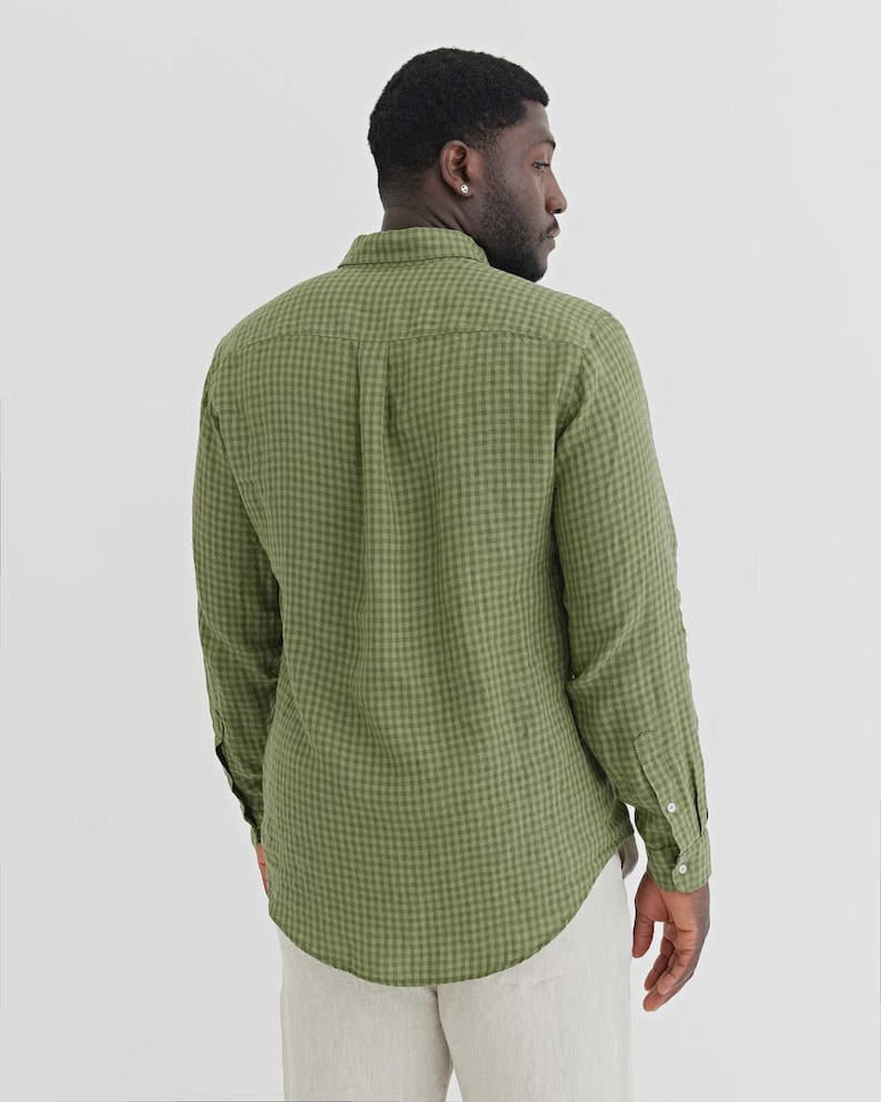 K&ouml;nnte beinhalten: Gr&uuml;nes Gingham-Hemd mit Kn&ouml;pfen, langen &Auml;rmeln und gekn&ouml;pften Manschetten. Das Hemd hat einen klassischen Kragen. Der Stoff hat eine subtile Textur. Das Hemd wird mit hellfarbigen Hosen getragen.