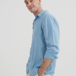 Pu&ograve; includere: Una camicia azzurra a maniche lunghe con colletto button-down. La camicia &egrave; realizzata in un tessuto leggero e ha una vestibilit&agrave; rilassata. Il modello indossa la camicia con pantaloni colorati chiari.