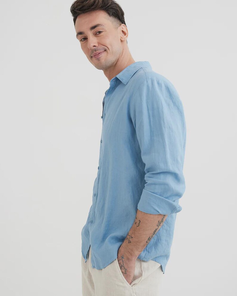 Pu&ograve; includere: Una camicia azzurra a maniche lunghe con colletto button-down. La camicia &egrave; realizzata in un tessuto leggero e ha una vestibilit&agrave; rilassata. Il modello indossa la camicia con pantaloni colorati chiari.