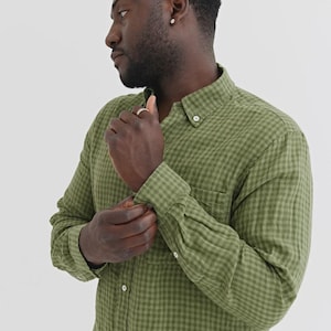 K&ouml;nnte beinhalten: Olivgr&uuml;nes Button-Down-Hemd mit kleinem Karomuster. Das lang&auml;rmlige Hemd hat einen Button-Down-Kragen und eine Brusttasche. Die Person im Bild passt die Manschette des Hemdes an.