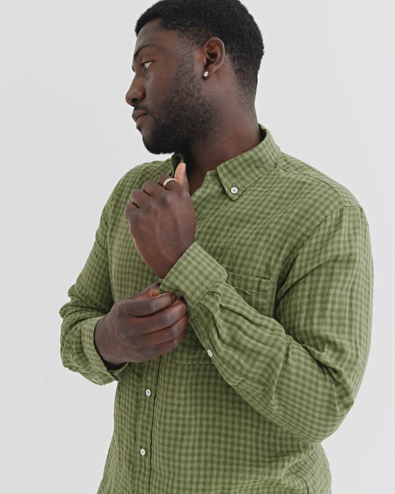 K&ouml;nnte beinhalten: Olivgr&uuml;nes Button-Down-Hemd mit kleinem Karomuster. Das lang&auml;rmlige Hemd hat einen Button-Down-Kragen und eine Brusttasche. Die Person im Bild passt die Manschette des Hemdes an.