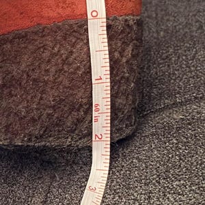 Puede incluir: Primer plano de un zapato marr&oacute;n y naranja con suela marr&oacute;n oscuro. Una cinta m&eacute;trica blanca muestra que la altura del zapato es de aproximadamente 5 cm. El zapato est&aacute; sobre una superficie gris.