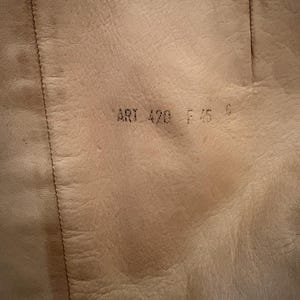 Puede incluir: Primer plano del interior de una bota de cuero marr&oacute;n claro. El texto "ART 420 F 45 6" est&aacute; estampado en el cuero. El cuero tiene grano y costuras visibles.