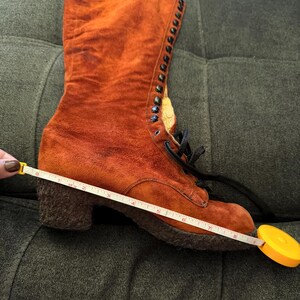 Puede incluir: Una bota de ante naranja con dise&ntilde;o de cordones. La bota tiene tac&oacute;n ancho y suela texturizada. La bota mide aproximadamente 20 cm de largo. La bota es de estilo vintage.