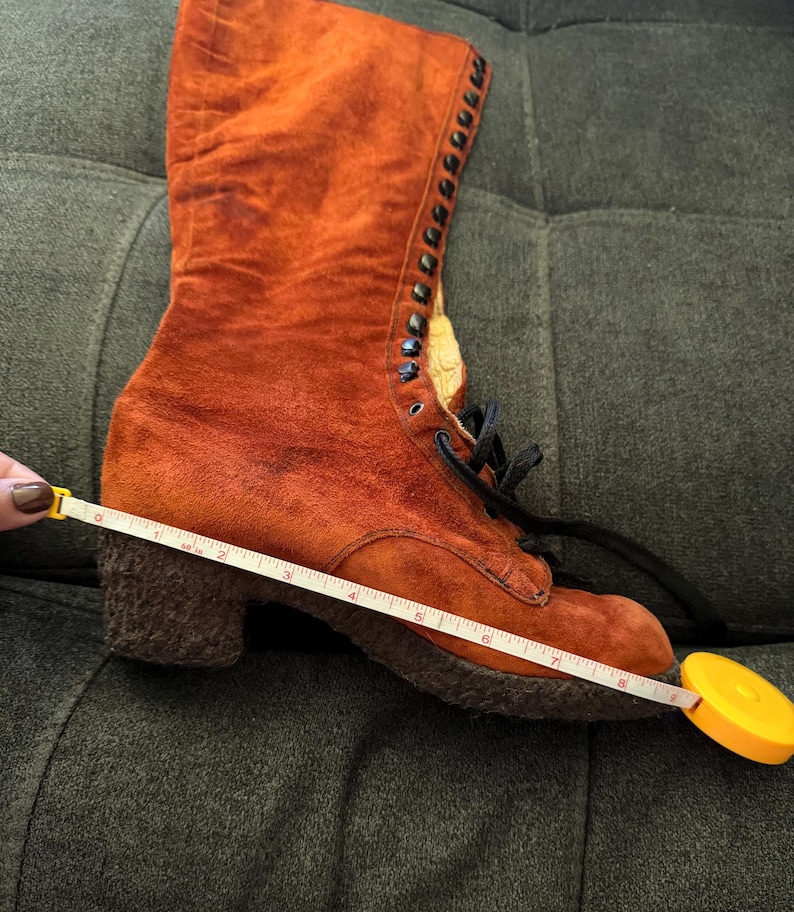 Puede incluir: Una bota de ante naranja con dise&ntilde;o de cordones. La bota tiene tac&oacute;n ancho y suela texturizada. La bota mide aproximadamente 20 cm de largo. La bota es de estilo vintage.
