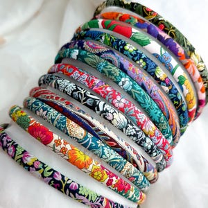 Peut inclure: Une pile de bandeaux en tissu colorés avec des motifs floraux et paisley.