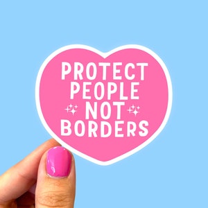 May include: Pink heart-shaped sticker with the text "PROTECT PEOPLE NOT BORDERS" in white lettering. The sticker has two small white stars on either side of the word "NOT".
