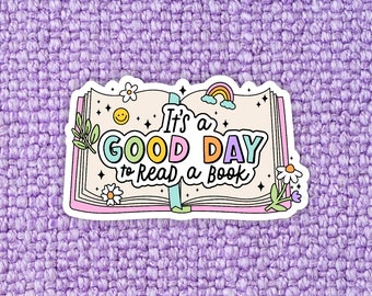 May include: A white sticker with a colorful open book design. The book has the text "It's a good day to read a book" in a rainbow font. The sticker has a rainbow, stars, and flowers.