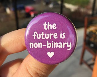 May include: Purple button with white text that reads "the future is non-binary" and a white heart.