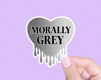 May include: A silver heart-shaped sticker with a dripping effect. The sticker has the text "MORALLY GREY" in black.