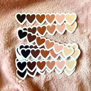 May include: A stack of heart-shaped stickers in various shades of brown, from dark brown to light beige. The stickers are arranged in rows, with each row containing a different shade of brown.