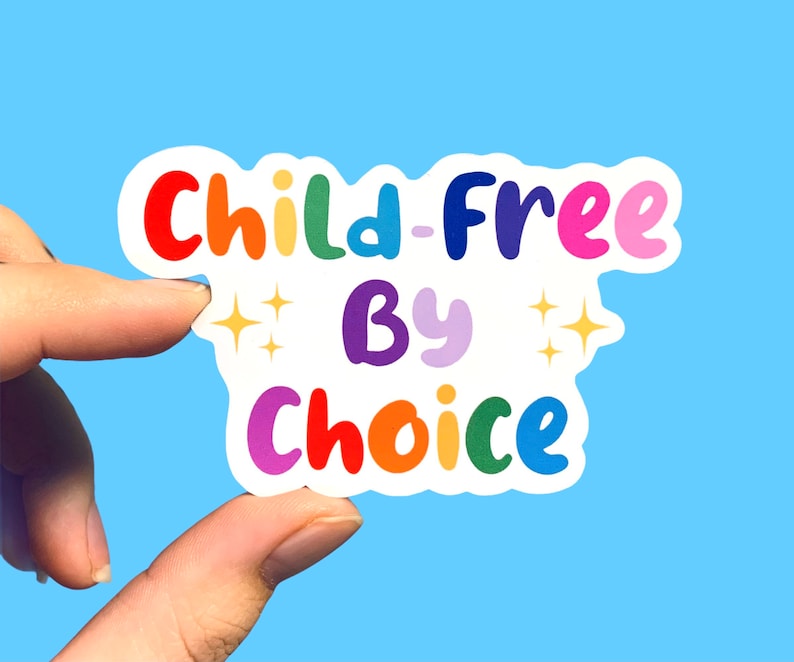 May include: A rainbow-coloured sticker with the text "Child-Free By Choice" in a playful font. The sticker has two small stars on either side of the word "By".