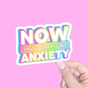May include: A rainbow-colored sticker with the text "NOW THAT'S WHAT I CALL ANXIETY".